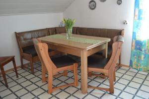 布里隆Almer Ferienwohnung的一张木桌,上面有两把椅子和一个花瓶