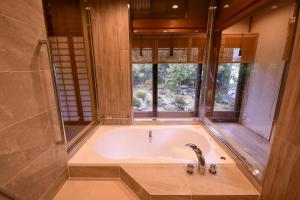 高野山高野山 宿坊 桜池院 -Koyasan Shukubo Yochiin-的带浴缸的浴室和窗户