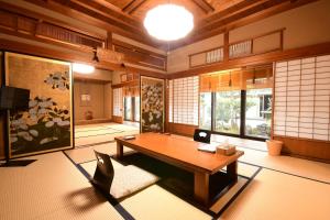 高野山高野山 宿坊 桜池院 -Koyasan Shukubo Yochiin-的客房设有木桌和一些窗户。