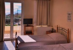 莫奈姆瓦夏依芙波利斯公寓酒店的一间卧室配有一张床、一台电视和一个阳台