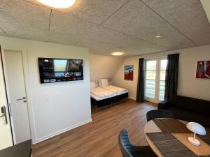 BredstenGo-Sleep Bredehus的客厅配有床和墙上的电视
