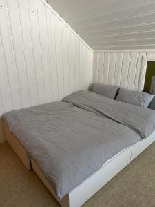 利勒哈默尔Stort hus sentralt i Lillehammer的白色墙壁间的一张床