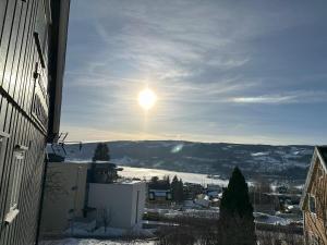 利勒哈默尔Stort hus sentralt i Lillehammer的天空中阳光灿烂的雪城景