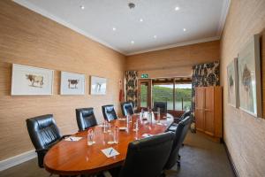 焦济尼Jozini Tiger Lodge & Spa by Dream Resorts的一间会议室,配有一张大木桌子和椅子