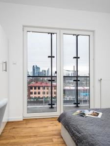 华沙Warsaw Apartments Bliska Wola的卧室设有大窗户,享有城市美景