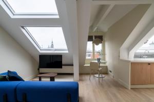阿姆斯特丹Numa Amsterdam Oosterpark的客厅设有天窗天花板和蓝色沙发。