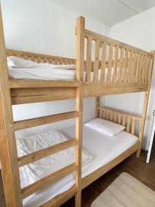 清刊Le Moon Hotel的一张带白色床单和枕头的木制双层床
