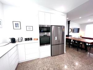 Vivonne BayWild Retreat - Luxury Home with Magnificent Views的厨房配有白色橱柜和不锈钢冰箱