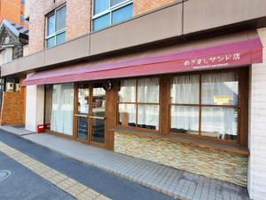 札幌ゲストハウス EZO Run Sapporo 札幌中心部でシンプルな滞在ができるホステル的砖楼前的商店,有窗户