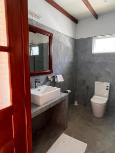 米瑞莎Bali Villa Mirissa的一间带水槽、卫生间和镜子的浴室