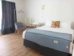 汉密尔顿Melville Guest House near Waikato Hospital的一间卧室配有一张床、一张桌子和一把椅子