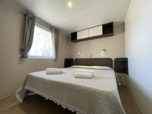 托尔托利Campeggio Villaggio Sos Flores的一间卧室配有一张床,上面有两条毛巾