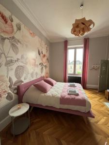 拉弗雷切La Parenthèse Fléchoise, Chambre Agathe的一间卧室配有一张带粉色毯子的大床