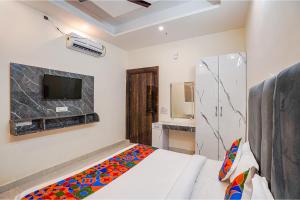 加济阿巴德FabExpress Red Diamond的卧室配有一张床,墙上配有电视。