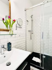 塔廷格Wellenreiter的白色的浴室设有水槽和玻璃淋浴间。