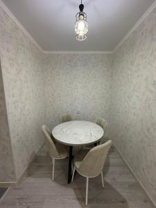 阿拉木图ЖК Ashyq Tobe的一间配备有白色桌椅的用餐室