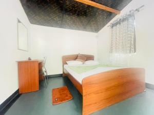 锡吉里亚Ima Villa Sigiriya的一间小卧室,配有木床和窗户