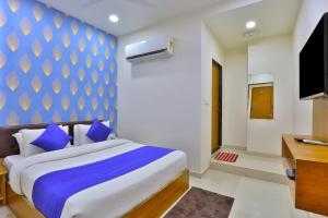 艾哈迈达巴德Hotel Shivaay的一间卧室配有一张蓝色和白色墙壁的床