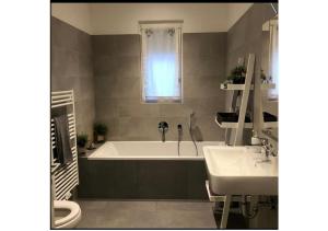 伊斯基亚Luxury house Marone的带浴缸、两个盥洗盆和窗户的浴室