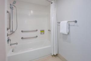 费尔法克斯费尔法克斯阿灵顿大道快捷假日酒店的白色的浴室设有淋浴和浴缸。