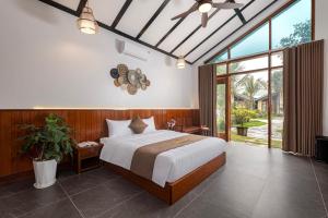 宁平La Vento Resort Ninh Bình的一间卧室设有一张大床和一个大窗户
