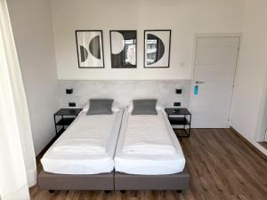 托尔博莱Villa Paola B&B的一间卧室设有两张床和两张边桌