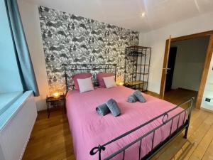 巴蒂斯Gite Pays de Herve - Emeraude的卧室配有粉红色的床和2个枕头