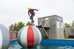 比迪福德Adventure Lodges and Retreats的水中一个男子在球上骑滑板