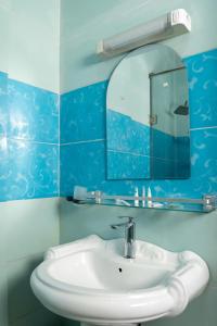雅温得CINCINNATI HOTEL YAOUNDE的浴室设有白色水槽和镜子
