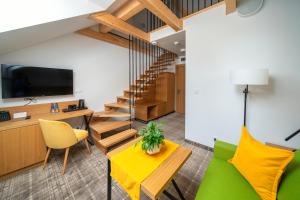 什恰夫尼察Willa Pod Kolejką的客厅设有绿色沙发和木制楼梯