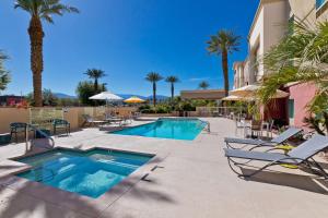 棕榈荒漠汉普顿棕榈沙漠套房酒店的一个带躺椅的游泳池,一个度假村
