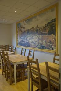 梅特科维奇Boutique Hostel Livia的用餐室配有桌椅,墙上挂有绘画作品