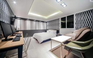 釜山Cheese Hotel Seomyeon的一间卧室配有一张床和一张带电脑的书桌