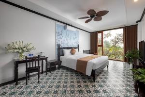 宁平La Vento Resort Ninh Bình的一间卧室配有一张床、一张桌子和一个窗户。