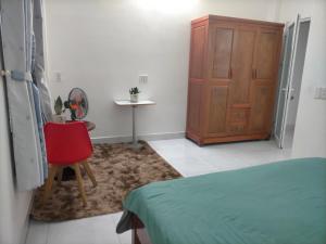 岘港TN's House的一间卧室配有一张床、一把椅子和一个橱柜
