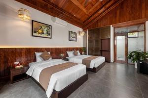 宁平La Vento Resort Ninh Bình的木墙客房的两张床