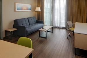 提华纳City Express Suites by Marriott Tijuana Rio的客厅配有沙发和桌子