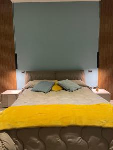 卡瓦德蒂雷尼Pergamena Bianca的一张带黄色毯子和两个枕头的床