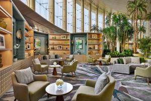 开罗Waldorf Astoria Cairo Heliopolis的大堂配有沙发和椅子,并种植了棕榈树。