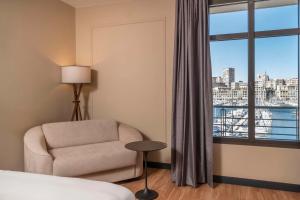 马赛马赛老港口丽笙酒店的酒店客房设有椅子和窗户。