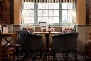 杜伦The Kingslodge Inn - The Inn Collection Group的餐厅设有桌椅和窗户。