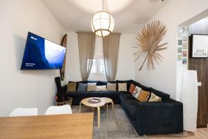 大加那利岛拉斯帕尔马斯Kite & Surf Nomad House的客厅配有黑色沙发和桌子