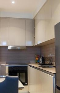 贝尔格莱德BW Aurora Lux Panorama的厨房配有白色橱柜和黑烤箱。