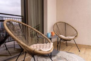 贝尔格莱德BW Aurora Lux Panorama的阳台配有2把藤椅和1张桌子