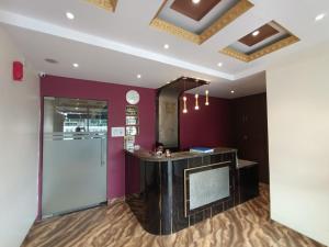 孟买Hotel Embassy Suites - Bandra Kurla Complex - BKC Mumbai的紫色墙壁的房间里酒吧