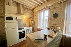 Le nid du coq d'or location appartement的厨房配有白色冰箱和台面