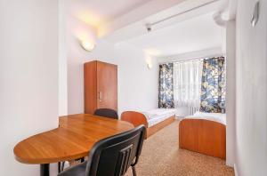 克拉科夫Hotel Biała Gwiazda的客房设有桌子、床和书桌。