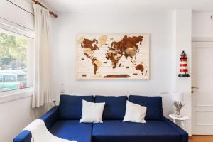 滨海圣波尔Hauzify I Apartament Can Bou的客厅里一张蓝色的沙发,上面有一张世界地图