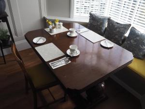 林顿South View Guest House的一张木桌,上面有杯子和碟子