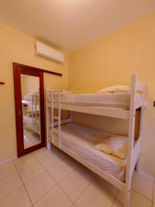 帕拉库鲁Pousada Viva Praia的客房设有两张双层床和镜子